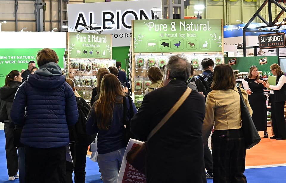 Figure 14. Albion Meat Products' Pure & Natural all-natural dog treats display on the PATS 2025 floor, with a visitor's show guide visible. Field photo from the author's on-site collection, PATS 2025.